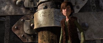 Movie still from “How to Train Your Dragon” (2010), directed by Chris Sanders – A boy standing in front of a large metal object; Medium shot, Low angle