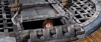 Movie still from “How to Train Your Dragon 2” (2014), directed by Dean DeBlois – A boy is peeking out of a metal structure; Wide shot, Overhead angle