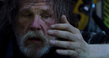 Movie still from “Hulk” (2003), directed by Ang Lee – An old man with a beard and mustache is holding his hand up to his face; Close Up shot, Low angle