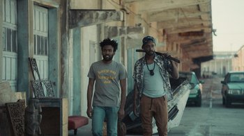 Movie still from “Atlanta” (2016), created by Donald Glover – A couple of men standing next to each other in an alley; Medium shot, Low angle