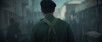 Movie still from “Hunt” (2022), directed by Lee Jung-jae – A man in a green jacket and a black hat; Close Up shot, Over the shoulder angle