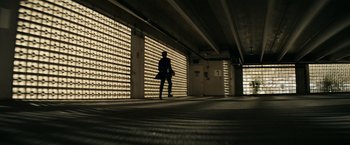 Movie still from “Hypnotic” (2023), directed by Robert Rodriguez – A person is standing in a building with a bag; Extreme Wide shot, Low angle