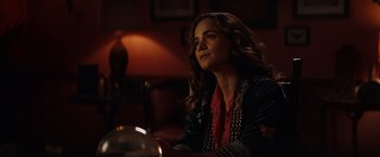 Movie still from “Hypnotic” (2023), directed by Robert Rodriguez – A woman sitting at a table in front of a lamp; Close Up shot, Over the shoulder angle