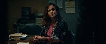 Movie still from “Hypnotic” (2023), directed by Robert Rodriguez – A woman sitting at a table in front of a wall; Close Up shot, Over the shoulder angle