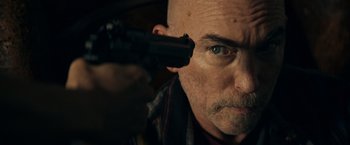 Movie still from “Hypnotic” (2023), directed by Robert Rodriguez – A man with a gun pointed to his head; Close Up shot, Low angle