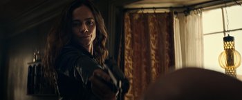 Movie still from “Hypnotic” (2023), directed by Robert Rodriguez – A woman holding a gun in a room with curtains; Close Up shot, Over the shoulder angle