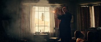 Movie still from “Hypnotic” (2023), directed by Robert Rodriguez – A man is holding a light in his hand; Medium shot, Low angle