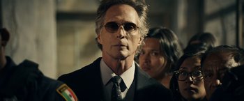 Movie still from “Hypnotic” (2023), directed by Robert Rodriguez – A man in a suit and tie next to a woman in a black suit; Close Up shot, Low angle