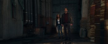 Movie still from “Hypnotic” (2023), directed by Robert Rodriguez – A man and a woman standing next to each other in the dark; Wide shot, Low angle
