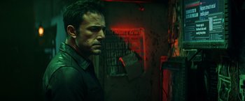 Movie still from “Hypnotic” (2023), directed by Robert Rodriguez – A man standing in a dark room with red lighting; Medium shot, Low angle