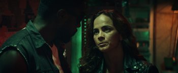 Movie still from “Hypnotic” (2023), directed by Robert Rodriguez – A woman with long dark curly hair looking at the camera with a man standing next to her; Close Up shot, Over the shoulder angle