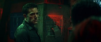 Movie still from “Hypnotic” (2023), directed by Robert Rodriguez – A man standing next to a wall in a dark room; Close Up shot, Over the shoulder angle