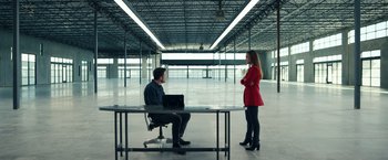 Movie still from “Hypnotic” (2023), directed by Robert Rodriguez – A man and a woman sitting at a table in an empty room; Wide shot, Low angle