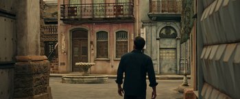 Movie still from “Hypnotic” (2023), directed by Robert Rodriguez – A man standing in front of an old building; Wide shot, High angle