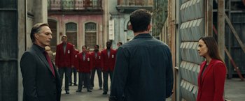 Movie still from “Hypnotic” (2023), directed by Robert Rodriguez – A group of men standing next to each other on a street; Wide shot, Over the shoulder angle