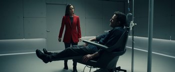 Movie still from “Hypnotic” (2023), directed by Robert Rodriguez – A man sitting on a chair in front of a woman; Medium shot, High angle