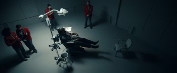 Movie still from “Hypnotic” (2023), directed by Robert Rodriguez – A man sitting in a dentist's chair in the dark; Wide shot, Overhead angle