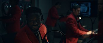 Movie still from “Hypnotic” (2023), directed by Robert Rodriguez – A man in a red jacket and headphones; Close Up shot, Over the shoulder angle