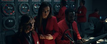 Movie still from “Hypnotic” (2023), directed by Robert Rodriguez – A group of people standing next to each other in a room; Medium shot, Over the shoulder angle