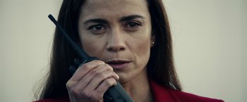 Movie still from “Hypnotic” (2023), directed by Robert Rodriguez – A person holding a walkie talkie; Close Up shot, Low angle