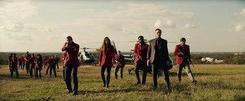 Movie still from “Hypnotic” (2023), directed by Robert Rodriguez – A group of people standing on top of a grass covered field; Extreme Wide shot, Low angle