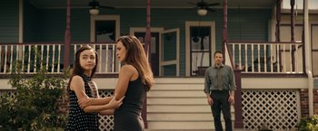 Movie still from “Hypnotic” (2023), directed by Robert Rodriguez – Two women and a man standing in front of a house; Medium shot, Over the shoulder angle