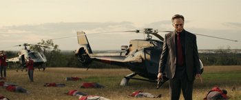 Movie still from “Hypnotic” (2023), directed by Robert Rodriguez – A man standing in front of a helicopter on the grass; Wide shot, Low angle