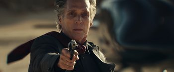 Movie still from “Hypnotic” (2023), directed by Robert Rodriguez – A man in a suit and tie holding a gun in his hand; Close Up shot, Over the shoulder angle