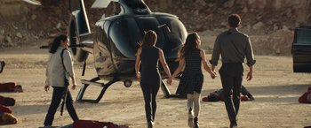 Movie still from “Hypnotic” (2023), directed by Robert Rodriguez – Two young women walking towards a helicopter on the ground; Wide shot, High angle