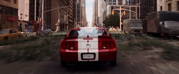 Movie still from “I Am Legend” (2007), directed by Francis Lawrence – The back of a red and white car driving down the street; Wide shot, High angle
