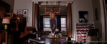 Movie still from “I Am Legend” (2007), directed by Francis Lawrence – A man is doing pull - ups in a gym; Wide shot, Low angle