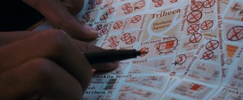 Movie still from “I Am Legend” (2007), directed by Francis Lawrence – A person holding a pen on a street map; Extreme Close Up shot, Overhead angle