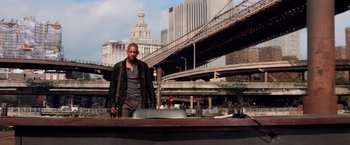 Movie still from “I Am Legend” (2007), directed by Francis Lawrence – A man standing on top of a boat near a bridge; Wide shot, Low angle