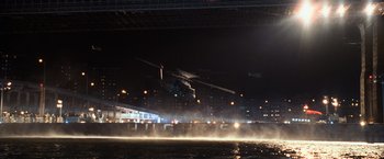 Movie still from “I Am Legend” (2007), directed by Francis Lawrence – A helicopter flying over a body of water at night; Extreme Wide shot, High angle