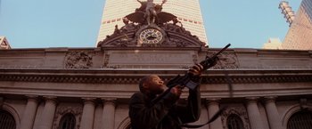 Movie still from “I Am Legend” (2007), directed by Francis Lawrence – A man holding a rifle in front of a building; Wide shot, Low angle