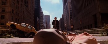 Movie still from “I Am Legend” (2007), directed by Francis Lawrence – A man standing on the side of the road in the middle of a city; Wide shot, High angle