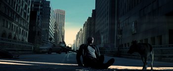 Movie still from “I Am Legend” (2007), directed by Francis Lawrence – A man sitting on the side of the road in the middle of the day; Wide shot, Low angle