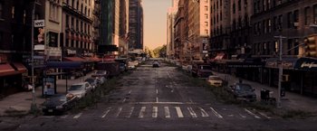 Movie still from “I Am Legend” (2007), directed by Francis Lawrence – An empty city street with cars parked on the side of the road; Extreme Wide shot, High angle