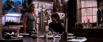 Movie still from “I Am Legend” (2007), directed by Francis Lawrence – Two people sitting at a table in front of a refrigerator; Medium shot, Over the shoulder angle