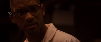 Movie still from “I Am Legend” (2007), directed by Francis Lawrence – A person wearing a shirt and glasses; Close Up shot, Over the shoulder angle