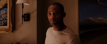 Movie still from “I Am Legend” (2007), directed by Francis Lawrence – A person wearing a white t - shirt; Close Up shot, Over the shoulder angle