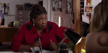 Movie still from “I Believe in Santa” (2022), directed by Alex Ranarivelo – A woman sitting at a table with a pen in her mouth; Close Up shot, High angle