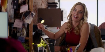 Movie still from “I Believe in Santa” (2022), directed by Alex Ranarivelo – A woman sitting at a table holding a light up cat; Close Up shot, Over the shoulder angle