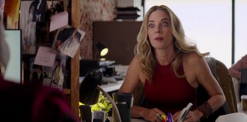 Movie still from “I Believe in Santa” (2022), directed by Alex Ranarivelo – A woman sitting at a desk looking up at the sky; Close Up shot, Over the shoulder angle