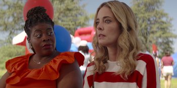Movie still from “I Believe in Santa” (2022), directed by Alex Ranarivelo – Two women standing next to each other in front of balloons; Close Up shot, Over the shoulder angle