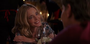 Movie still from “I Believe in Santa” (2022), directed by Alex Ranarivelo – A woman sitting at a table with a glass of red wine; Close Up shot, Over the shoulder angle