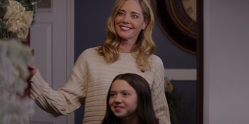Movie still from “I Believe in Santa” (2022), directed by Alex Ranarivelo – A woman standing next to a girl in a room; Medium shot, Over the shoulder angle