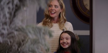 Movie still from “I Believe in Santa” (2022), directed by Alex Ranarivelo – A woman standing next to a young girl in front of a christmas tree; Medium shot, Over the shoulder angle