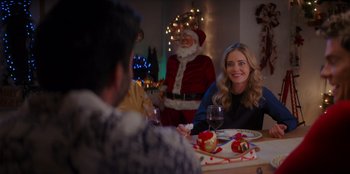 Movie still from “I Believe in Santa” (2022), directed by Alex Ranarivelo – A group of people sitting at a dinner table; Medium shot, Over the shoulder angle