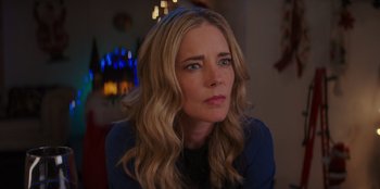 Movie still from “I Believe in Santa” (2022), directed by Alex Ranarivelo – A person sitting in a room near a window; Close Up shot, Over the shoulder angle